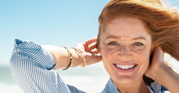 Frau lächelt und zeigt ihre geraden Zähne | Credit: iStock.com/Ridofranz