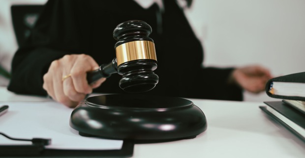 Frau hält Hammer für Gerichtsurteil in der Hand