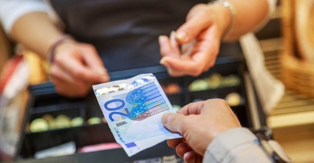 Frau zahlt mit einem 20 Euro-Schein | Credit: iStock.com/pixinoo