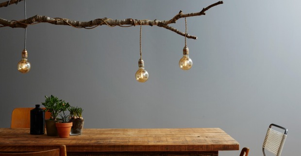 Ast mit Lichterkette hängt über einem Holztisch | Credit: iStock.com/Bernd Schwabedissen
