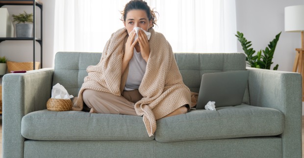 Frau mit Erkältung auf Sofa