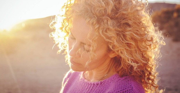 Junge Frau genießt mit geschlossenen Augen das Sonnenlicht | Credit: iStock.com/simonapilolla