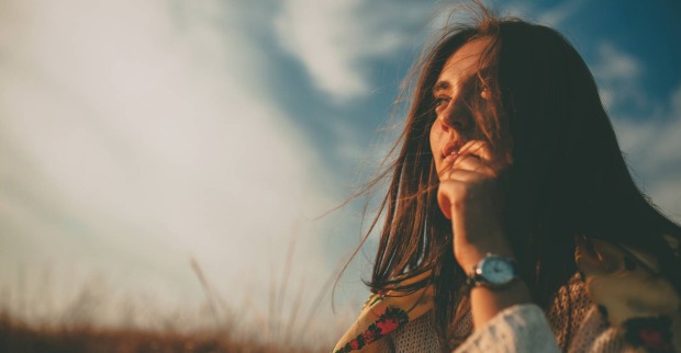 Junge Frau blickt nachdenklich in die Landschaft | Credit: iStock.com/max-kegfire