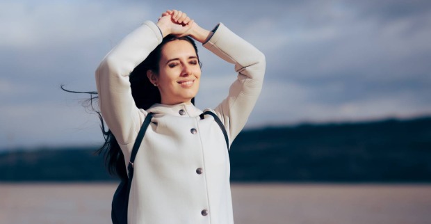 Junge Frau genießt die Sonne bei einem Winterspaziergang | Credit: iStock.com/nicoletaionescu