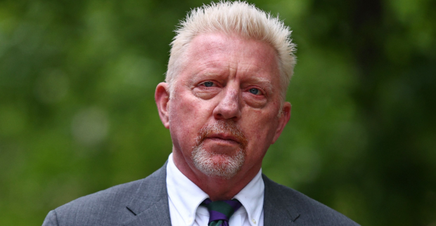 Porträt von Boris Becker, der einen grauen Anzug, ein weißes Hemd sowie eine grün-violett gestreifte Krawatte trägt