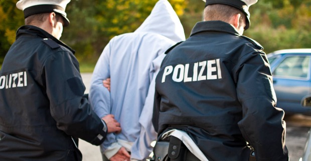 Mann wird von zwei Polizisten festgenommen