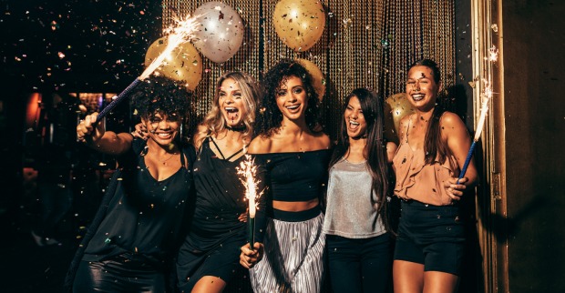 Fünf Frauen feiern ausgelassen in einem Club. | Credit: iStock.com/jacoblund