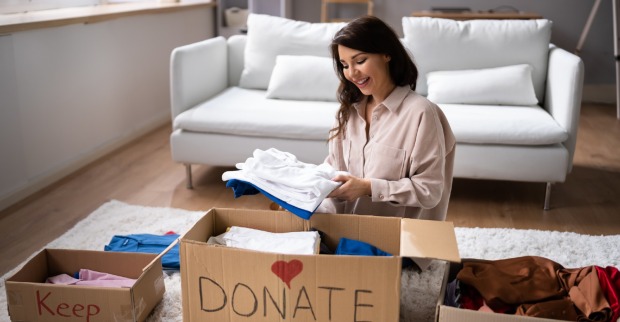 Frau sitzt in der Mitte von Kisten und ordnet ihr Zuhause | Credit: iStock.com/AndreyPopov
