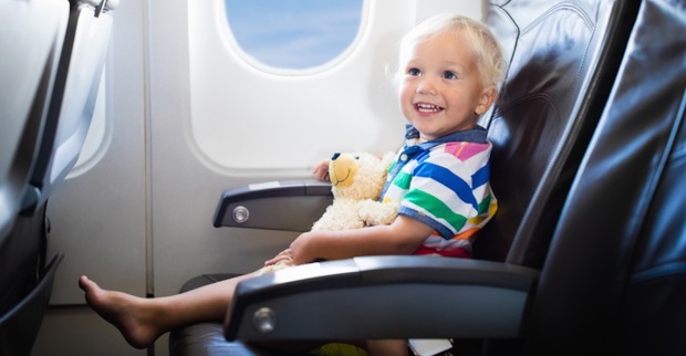 Kleinkind sitzt im Flugzeug und lacht