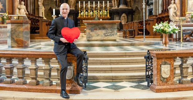 Dompfarrer Toni Faber hält am Altar ein Valentins-Herz| Credit: Stephan Schönlaub