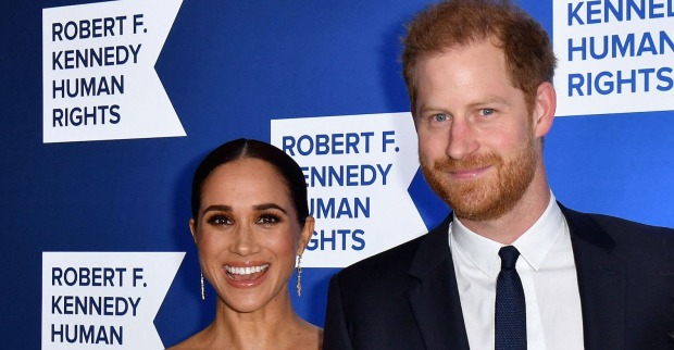 Harry und Meghan lachen mit Abendkleidung in die Kamera