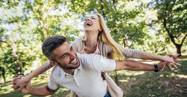 Pärchen läuft glücklich durch den Wald | Credit: iStock.com/Jovanmandic