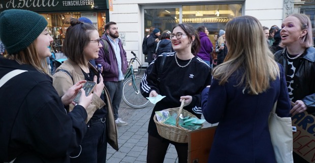 Junge Frauen bei der Verteilaktion in Graz. Sie lachen, die Stimmung wirkt gelöst.