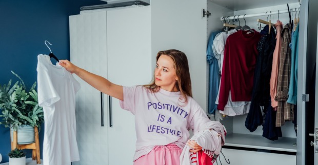 Frau organisiert ihren Kleiderschrank | Credit: iStock.com/OKrasyuk