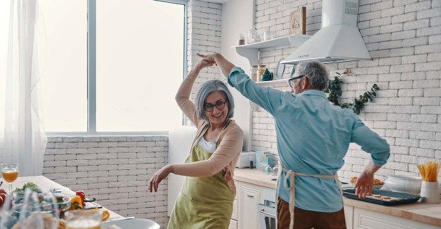 Älteres Paar kocht und tanzt zusammen | Credit: iStock.com/g-stockstudio