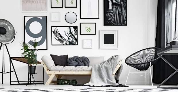 Viele unterschiedlich große Bilder hängen gemäß der Petersburger Hängung an der Wand | Credit: iStock.com/KatarzynaBialasiewicz