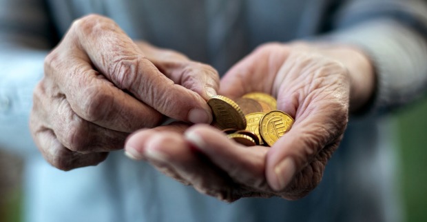 Hände einer älteren Frau mit Euro-Münzen