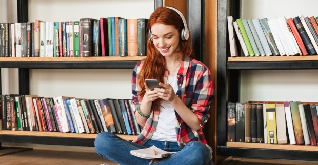 Mädchen sitzt vor einem Bücherregal | Credit: iStock.com/DeanDrobot