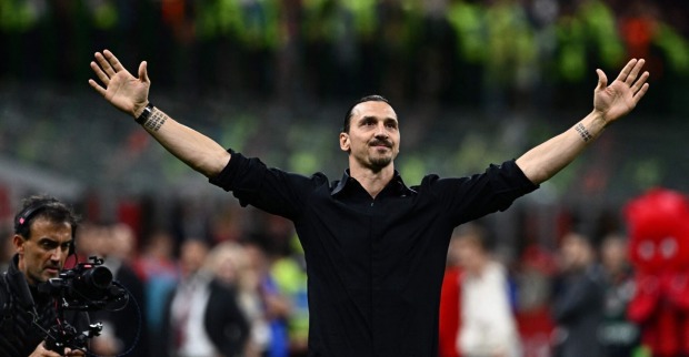 Der ganz in schwarz gekleidete Zlatan Ibrahimović mit weit ausgebreiteten Armen vor der Kulisse des Heimstadions des AC Milan