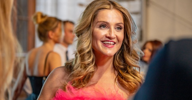 Eine Frau in einem Federnkleid mit langen Haaren und Locken