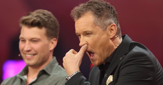 Armin Assinger im Studio von "Verstehen Sie Spaß?". Er greift sich an die Nase.