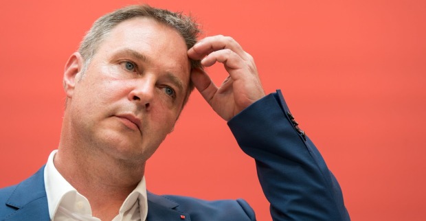 Andreas Babler bei einer Pressekonferenz vor der Pressewand der SPÖ. Er greift sich an den Kopf