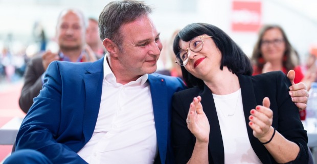 Babler sitzt neben seiner Lebensgefährtin und hat den Arm um sie. Die beiden schauen sich verliebt an.