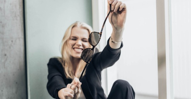 Frau zeigt, dass die Brille unzerbrechlich ist und in alle Richtungen gebogen werden kann