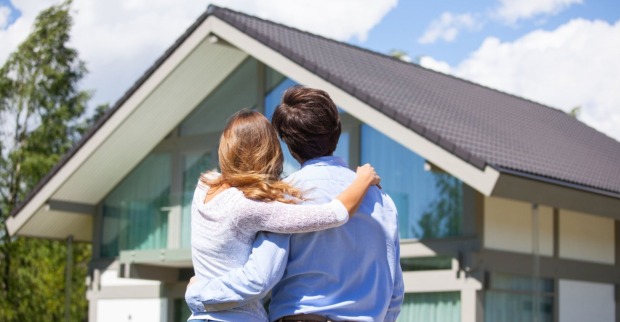 Ein Paar steht vor einem Haus | Credit: iStock.com/ALotOfPeople