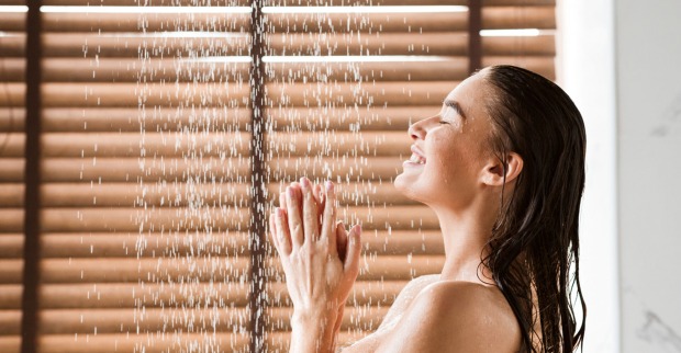 Frau unter dem Wasserstrahl einer Dusche.