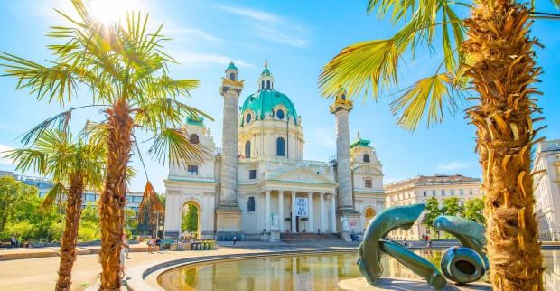 Palmen im Sonnenschein vor der Wiener Karlskirche | Credit: istock.com/arcady_31