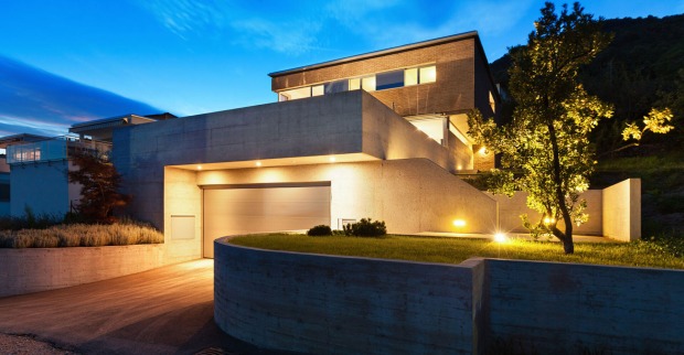Beleuchtetes modernes Wohnhaus in der Abenddämmerung | Credit: iStock.com/piovesempre