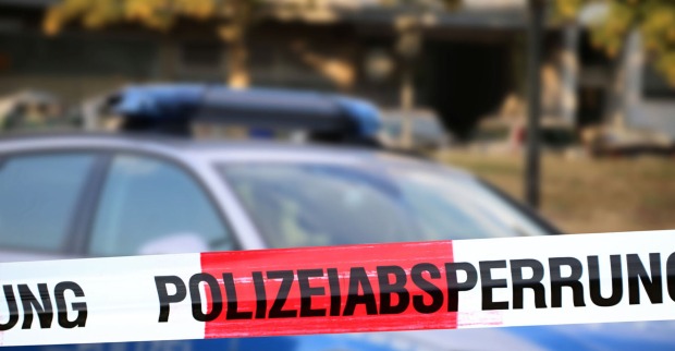 Polizeiabsperrung mit Polizeiauto im Hintergrund