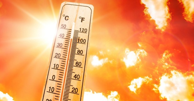 Ein Thermometer vor einem roten Himmel mit einer grellen Sonne. Es zeigt mehr als 35 Grad.