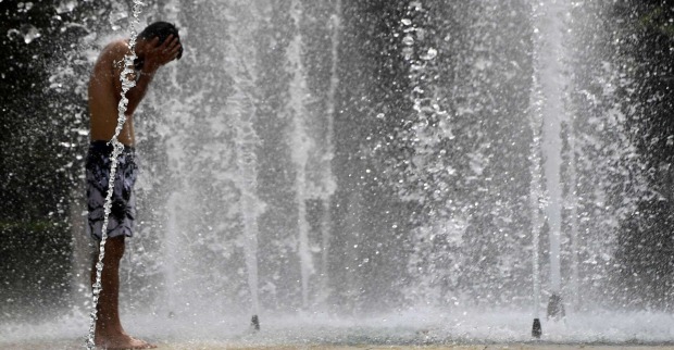 Bub kühlt sich in einem Brunnen ab.