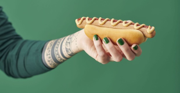 Eine Hand mit einem Hotdog.