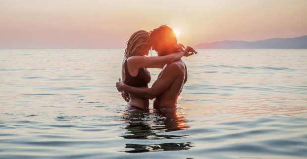 Verliebtes Paar beim Sonnenuntergang im Wasser