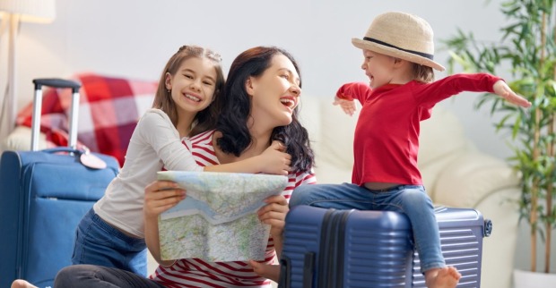 Mutter und zwei Kinder planen den Urlaub | Credit: iStock.com/Choreograph