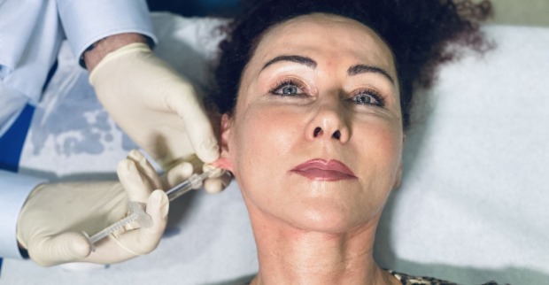 Der Arzt setzt bei Mausis Ohrläppchen die Botox-Spritze an.