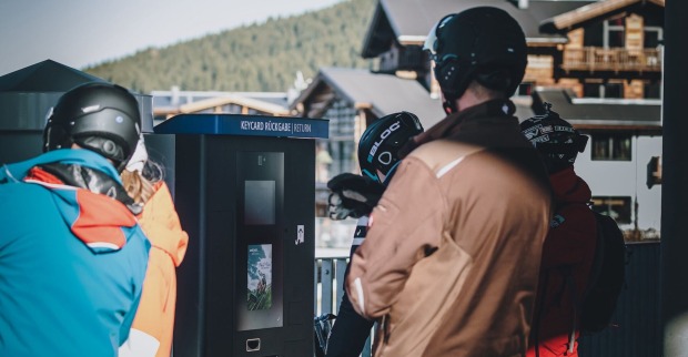 Skifahrer an einem Ticketautomat.