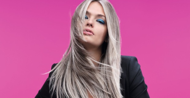 Blondes Model vor einer pinken Wand bei einem Fotoshootings