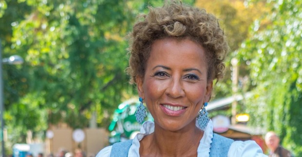 Arabella Kiesbauer vor einem begrünten Park