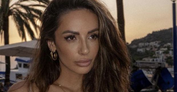 Bachelorette Jennifer Saro mit offenen braunen Haaren vor einer Palme