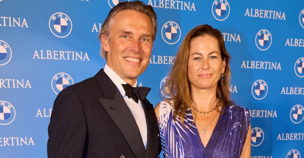 Birgit Lauda mit Partner Marcus Sieberer vor einer blauen Fotowand