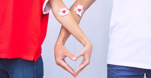 Zwei Blutspender mit Herzpflaster formen mit ihren Fingern ein Herz| Credit: istock.com/Daria Kulkova