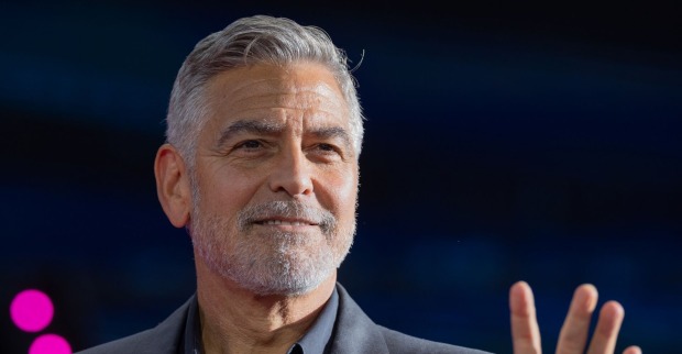 George Clooney winkt auf Podium Publikum zu