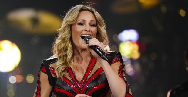 Helene Fischer singt in einem rot schwarzen Outfit mit einem Mikrofon in der Hand