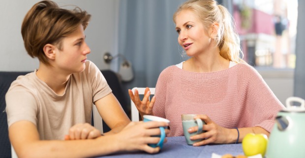 Sohn und Mutter sprechen beim Frühstück miteinander | Credit: istock.com/JackF