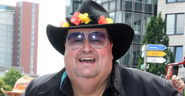 Andreas Ellermann mit einem schwarzen Hut und Blumendekoration in den Farben der Deutschland Flagge.