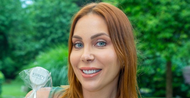 Tara Tabitha mit kupfer Haaren vor einem Park.